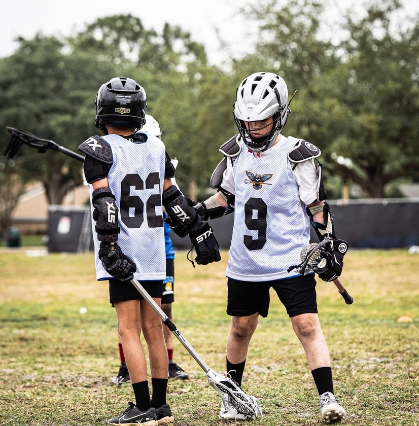 Youth lacrosse players competing in game